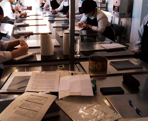 Personas en situación de vulnerabilidad participando en formación como ayudantes de cocina.